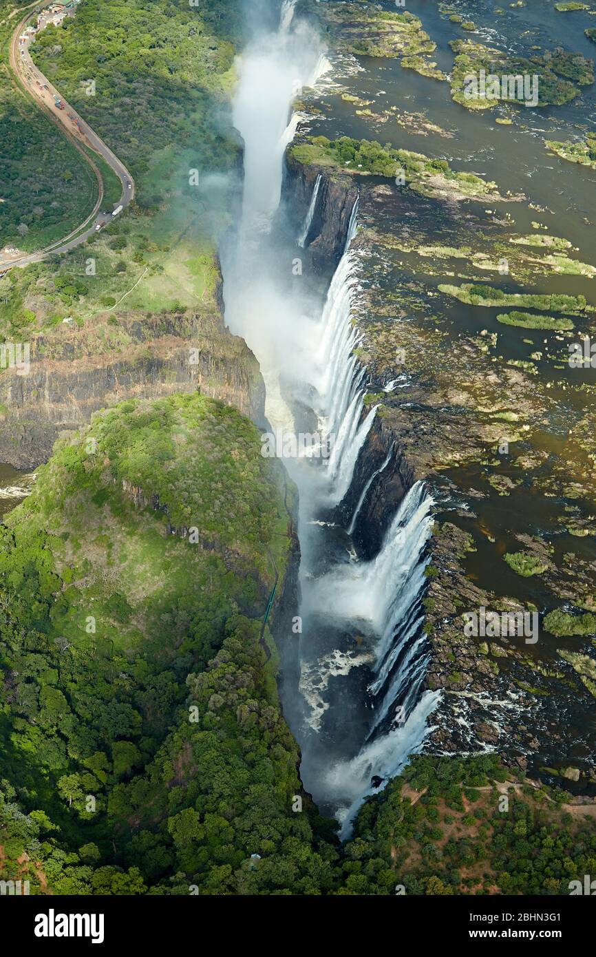 Victoria Falls or 'Mosi-oa-Tunya' (The Smoke that Thunders), and Zambezi River, Zimbabwe / Zambia border, Southern Africa - aerial Stock Photo