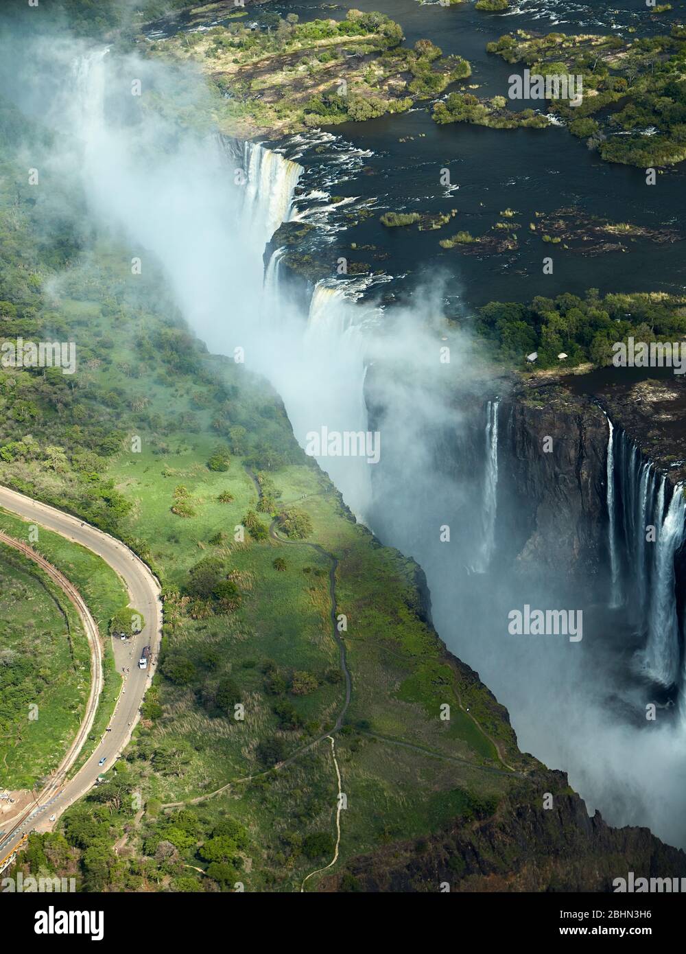 Victoria Falls or 'Mosi-oa-Tunya' (The Smoke that Thunders), and Zambezi River, Zimbabwe / Zambia border, Southern Africa - aerial Stock Photo