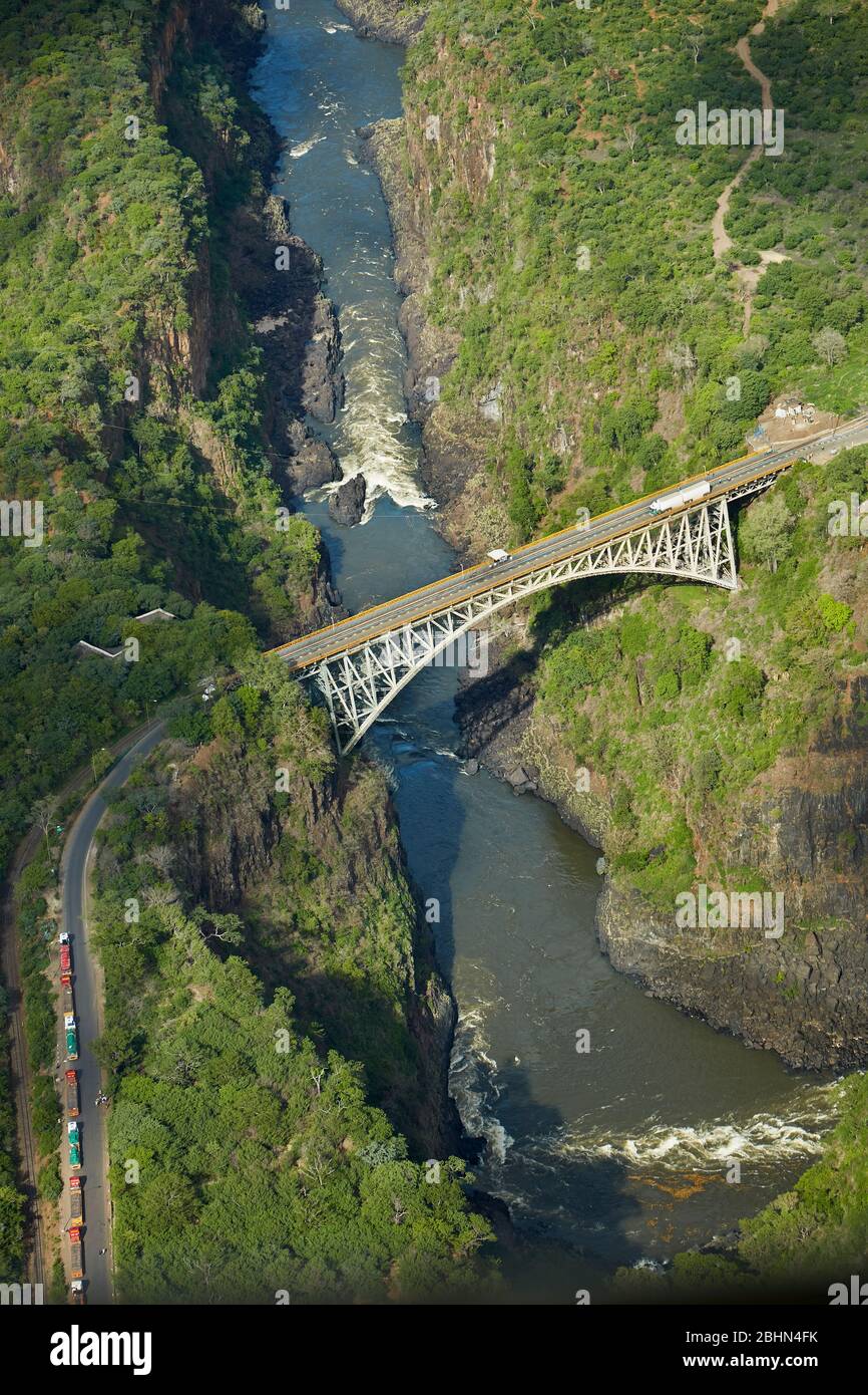 Historic Victoria Falls Bridge (1905), over Zambezi River, Batoka Gorge, below Victoria Falls, Zimbabwe / Zambia border, Southern Africa - aerial Stock Photo