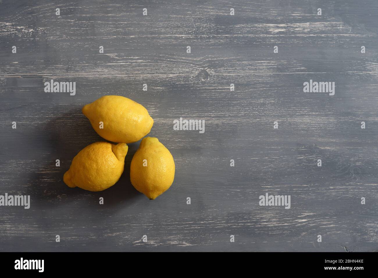 Three lemons over a grey table Stock Photo