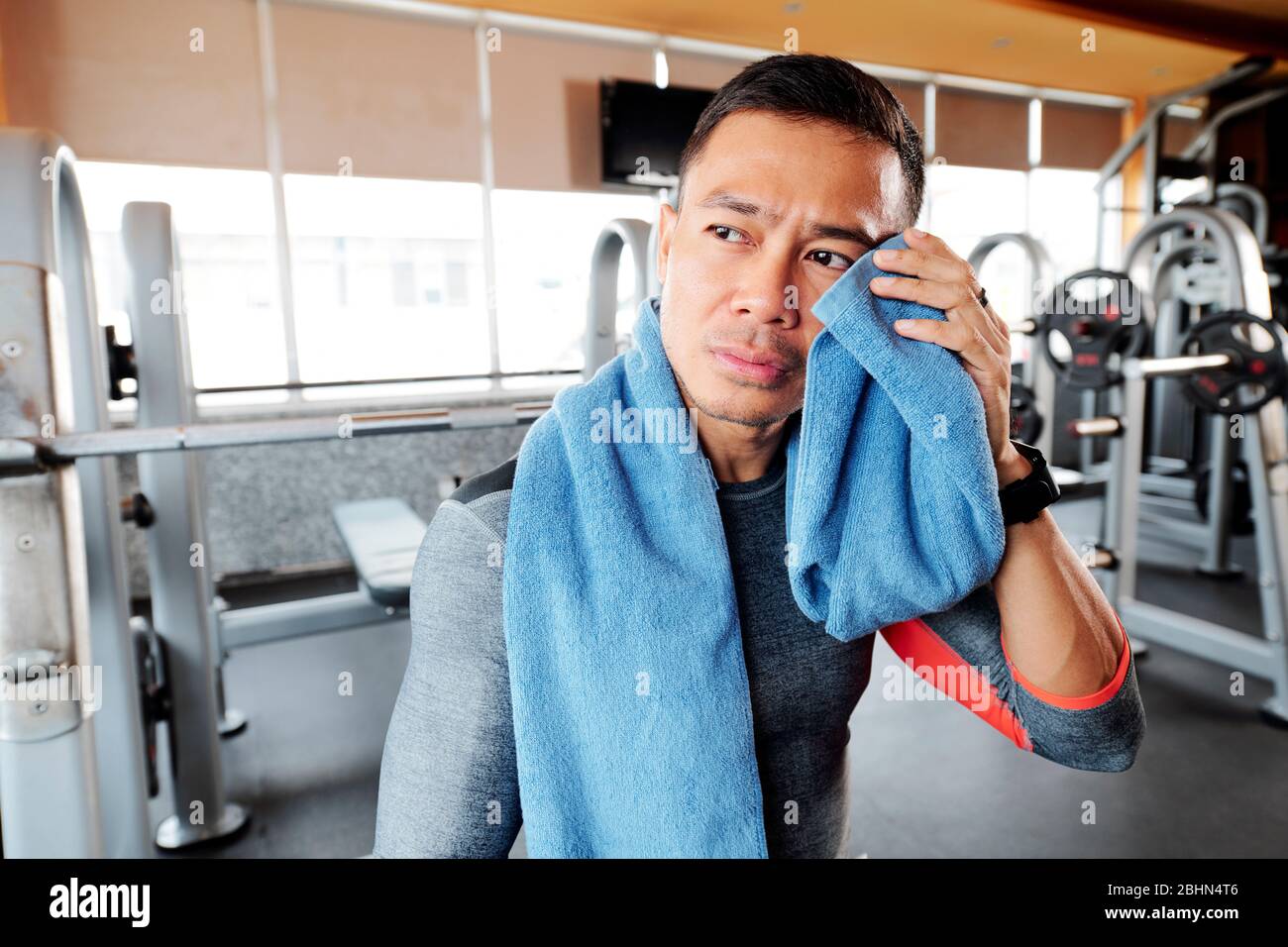 Sweaty after great work out. Handsome young men in sportswear whipping  sweat with his towel and holding water bottle while sitting at gym 13487667  Stock Photo at Vecteezy