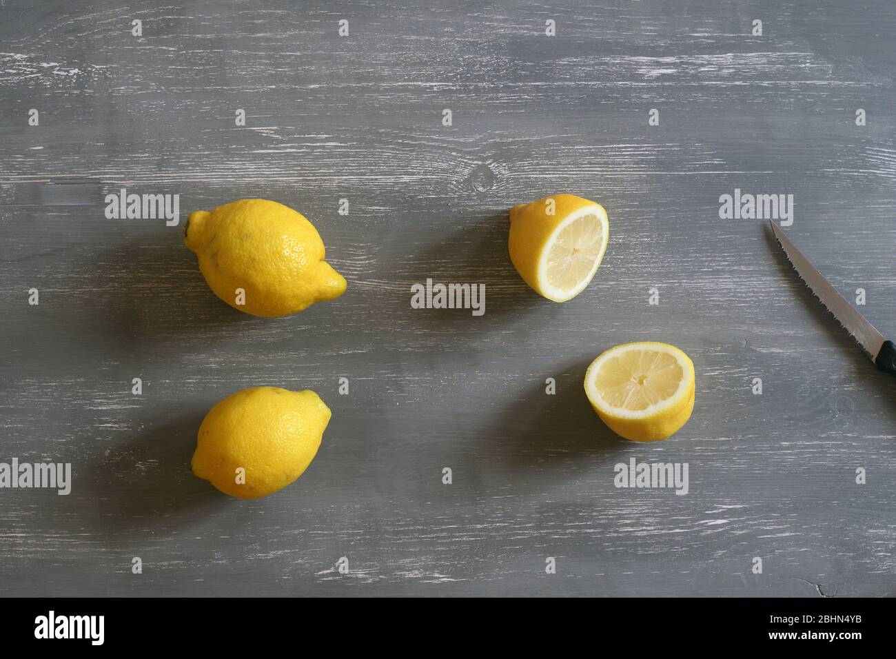 Two lemons and one cut in half Stock Photo