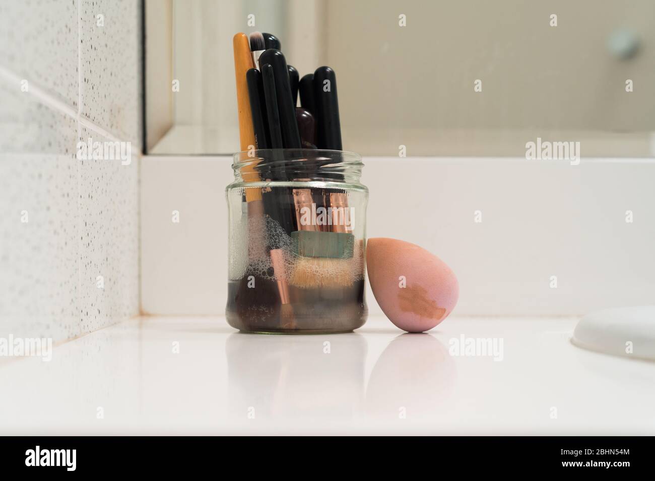 soaking brushes in a soapy water solution before cleaning Stock Photo