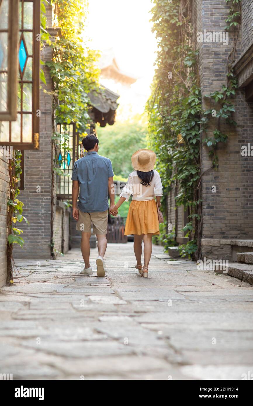 Young Chinese couple walking in alley Stock Photo - Alamy