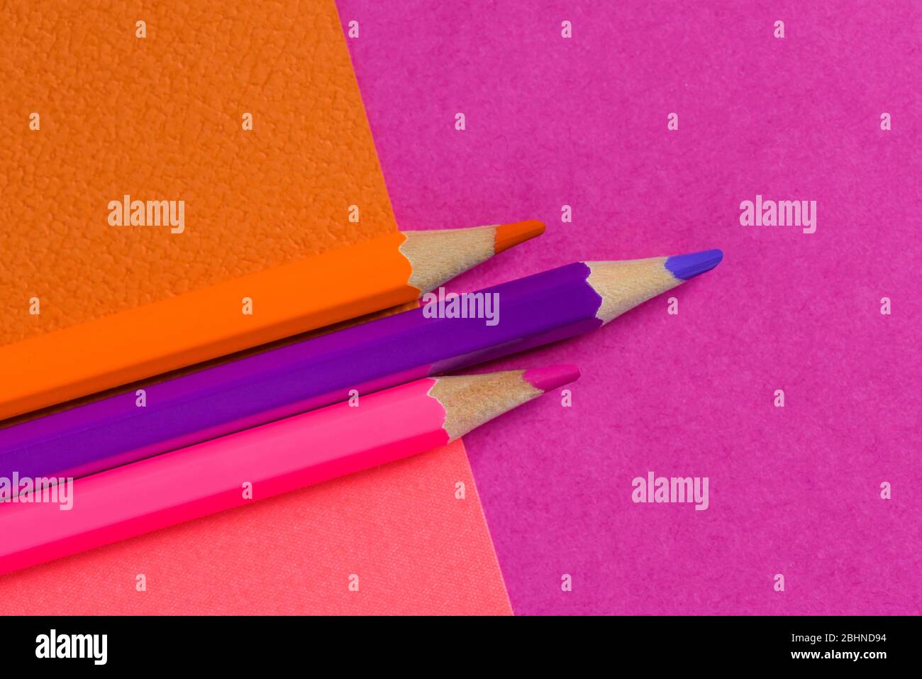 Pink color pencils on pink background. Pink designer paper. Concept of