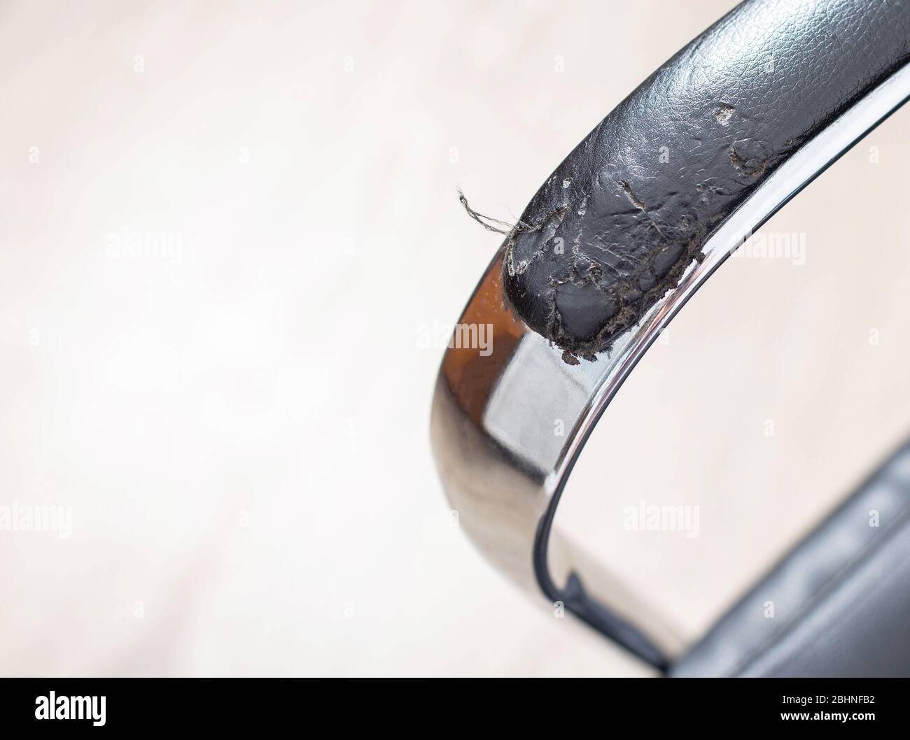Torn and battered leather on a black office computer chair. Restoration