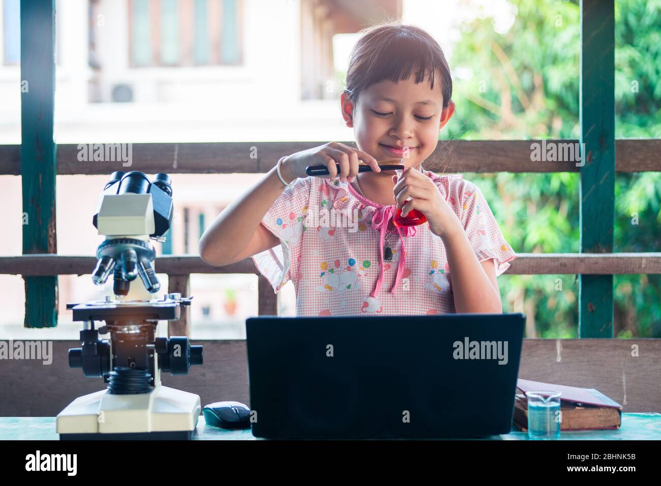 Smile little child girl learning and making science experiments. Home School Education concept. Stock Photo
