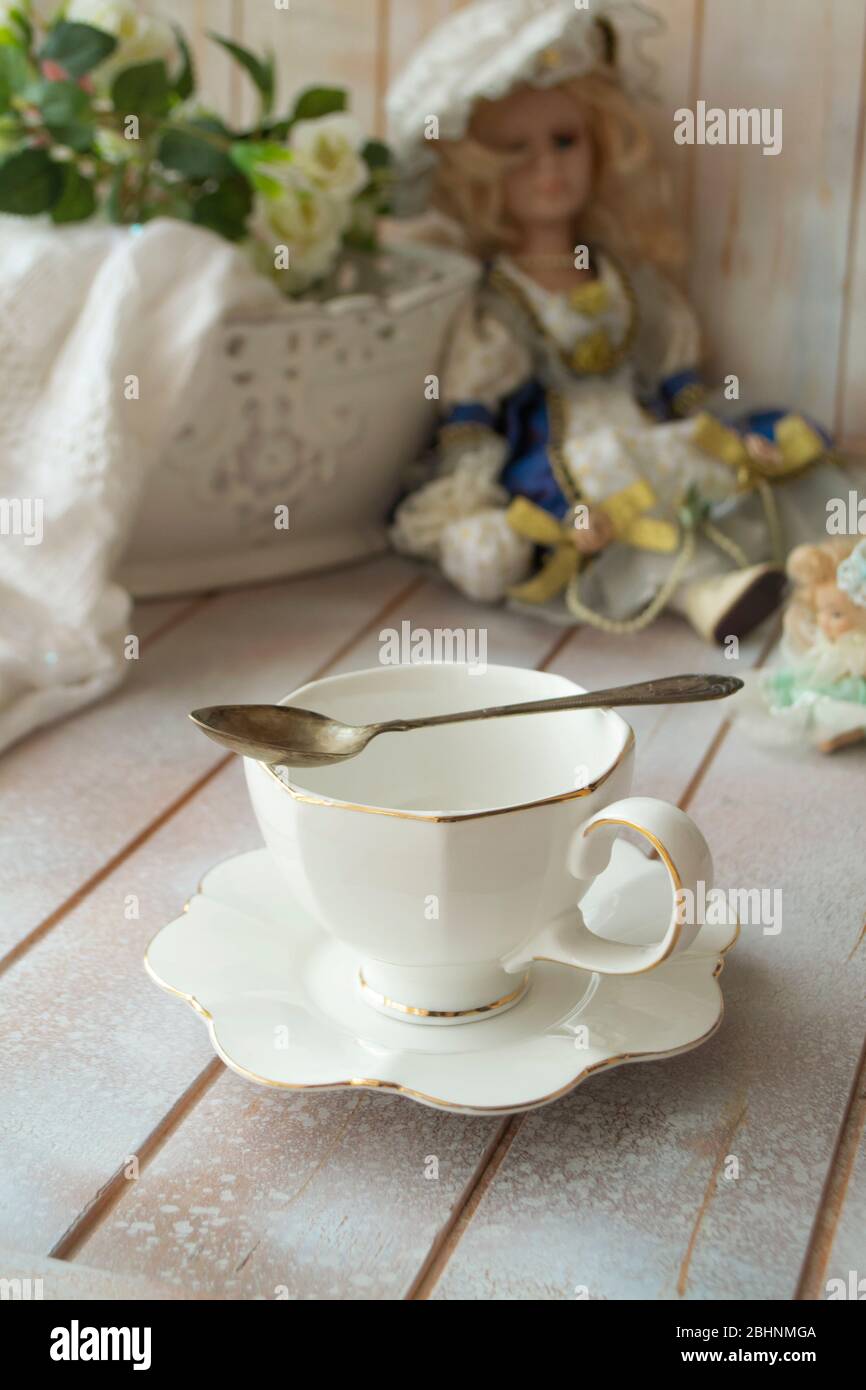 Elegant antique white tea cup on shabby table, vertical Stock Photo
