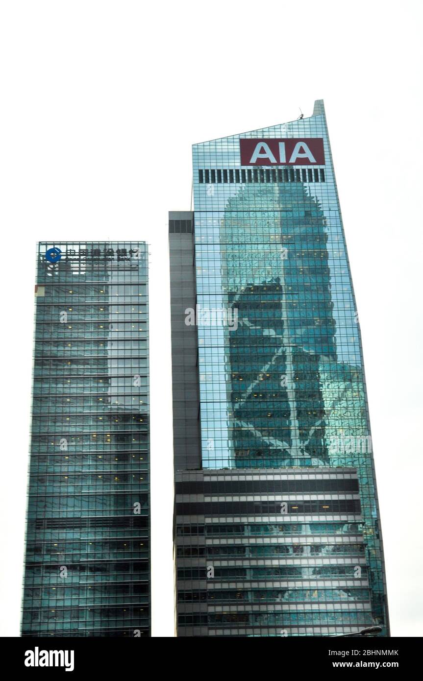 HONG KONG, June,10 2013: Bank of China tower reflected over the facade of the AIA headquarter Tower, a modern glass and steel office skyscraper Stock Photo