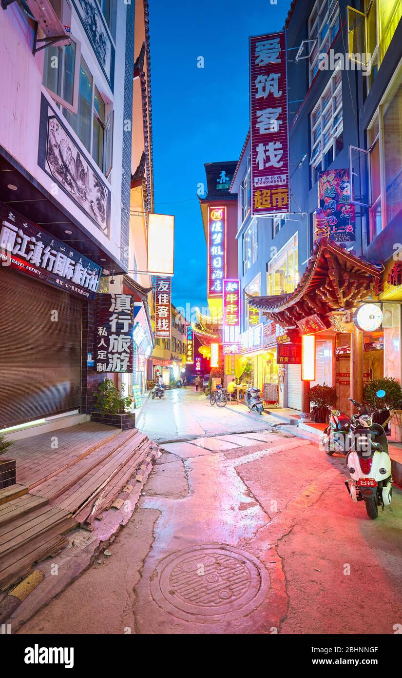 Lijiang, China - September 27, 2017: Street of Lijiang touristic area illuminated by advertising signs with Chinese characters at night. Stock Photo