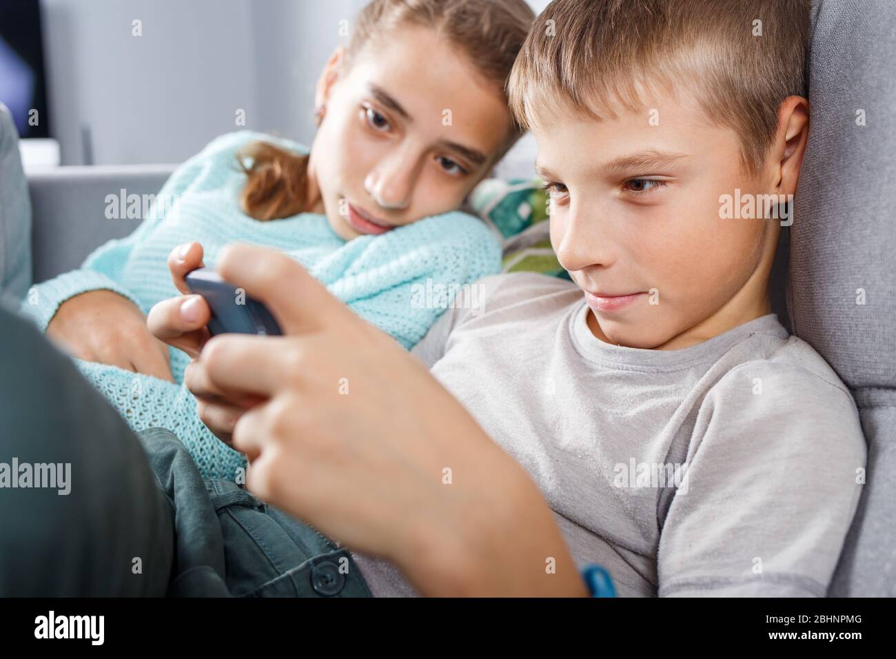 Boy with his sister spending time online at home on quarantine Stock Photo