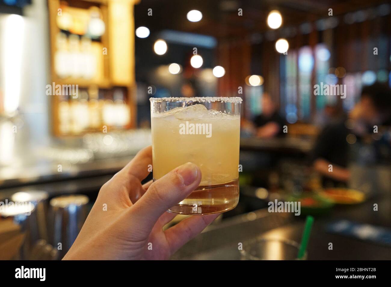 Hand holding A glass of Margarita cocktail consisting of tequila