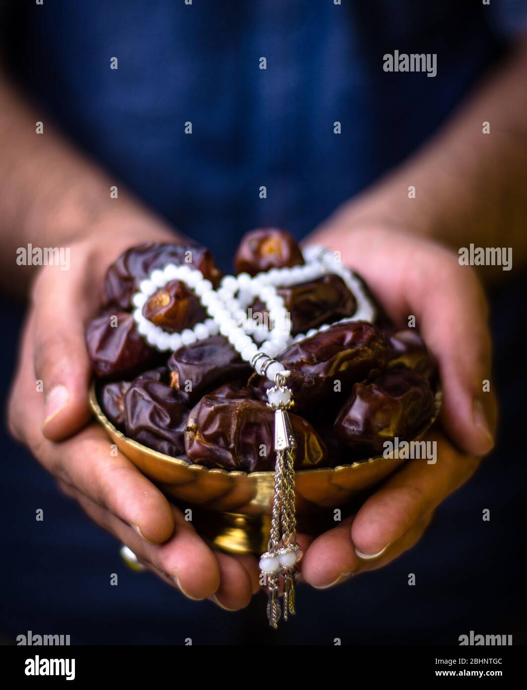 Ramadan Background holding dates in his hands with tasbeeh ramadan mubarak concept, fasting and iftar fruits islamic background Stock Photo