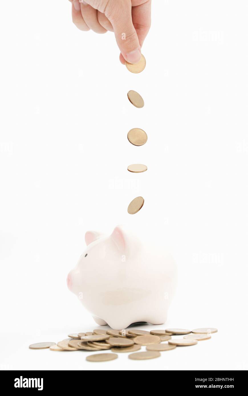 hand putting a coin into piggy bank isolated Stock Photo - Alamy