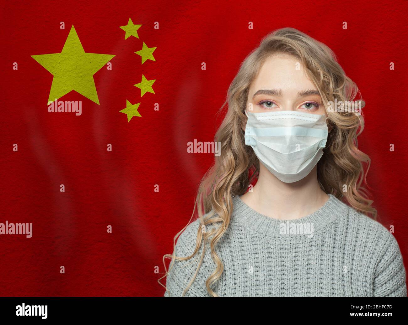 Young woman wearing a face mask with national flag China. Flu epidemic and virus protection concept Stock Photo