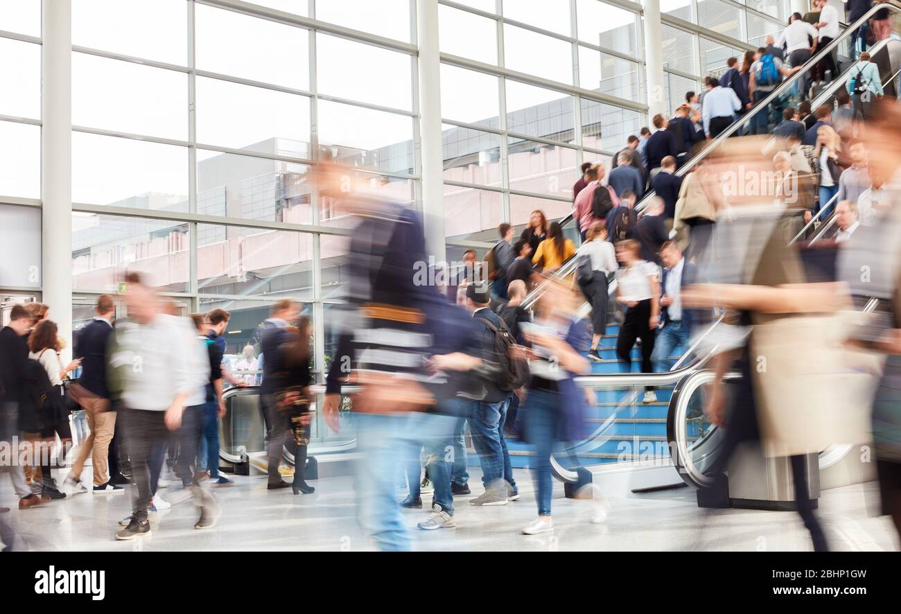 Many anonymous blurred people as crowd on escalator in the airport Stock Photo