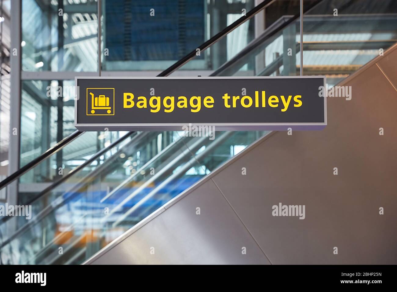 Airport terminal signs, luggage trolleys Stock Photo Alamy