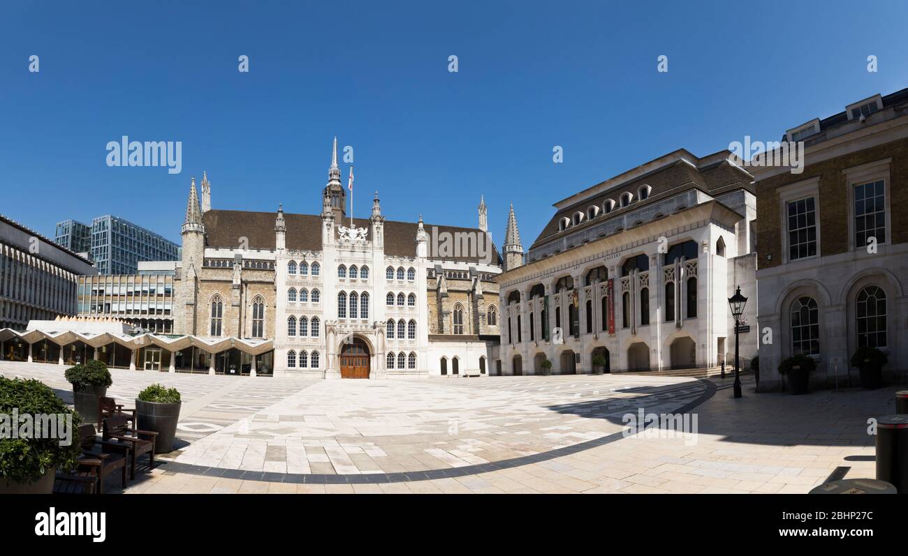 Panorama / panoramic view of the Guildhall Great Hall, centre; Aldermens Court / West wing (L); Art Gallery (R). City of London UK. On the ground an 80 m wide curved line of dark stone follows the edge of the original Roman amphitheatre. (118) Stock Photo
