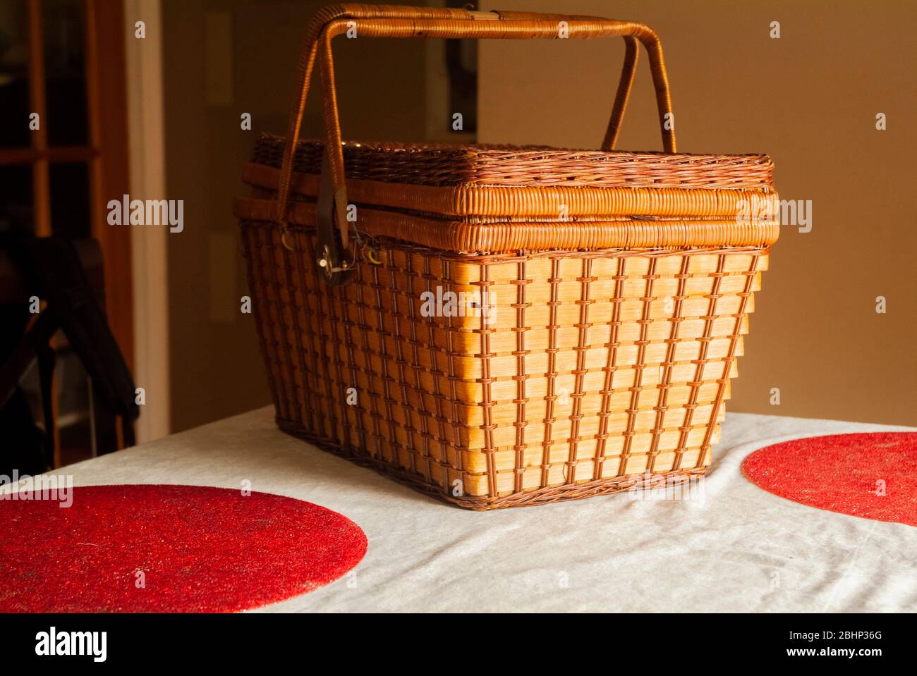 HOME SCHOOLING: Book bags hang on the back of kitchen chairs beside a picnic basket on a table. Stock Photo