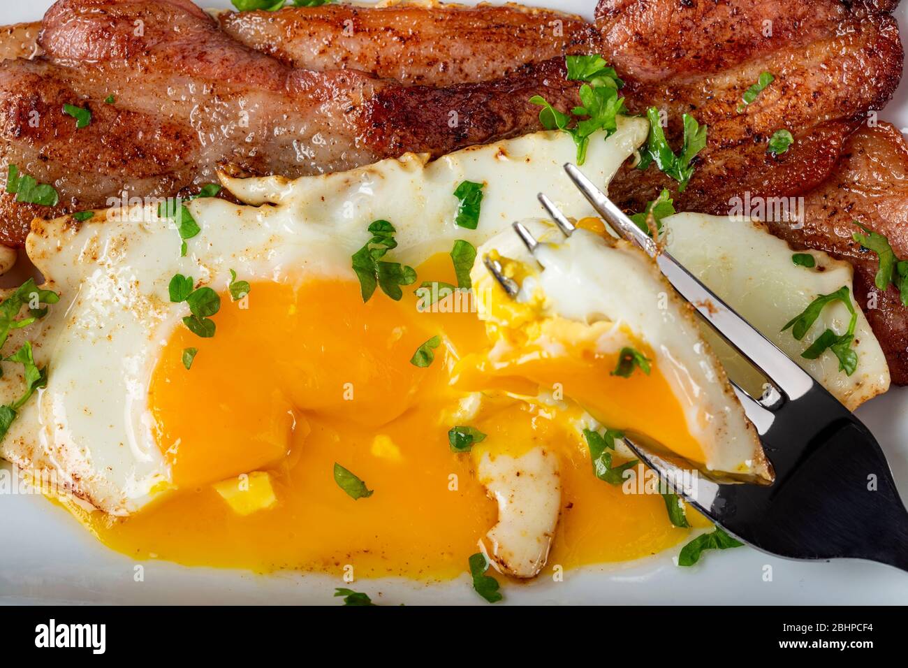 Eating eggs and bacon with fresh green herbs Stock Photo Alamy