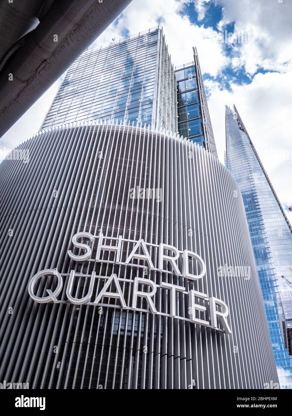 The Shard Quarter. Low, wide angle view of the iconic London Shard building with foreground signage and neighbouring architecture. Stock Photo