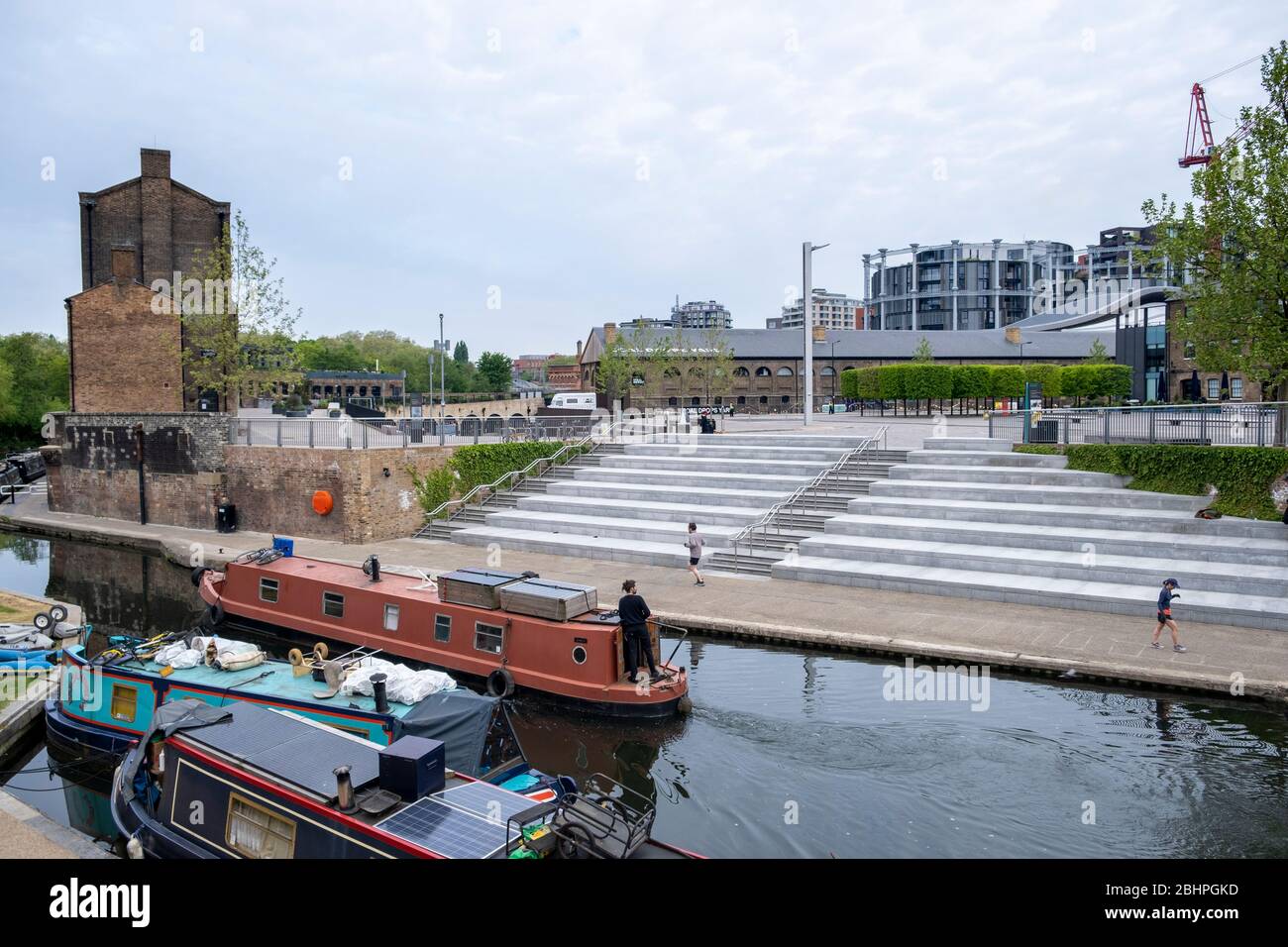 London lockdown: a barge on Regents Canal passes Granary Square, Kings Cross, normally busy but empty due to covid-10 lockdown in the London, UK Stock Photo