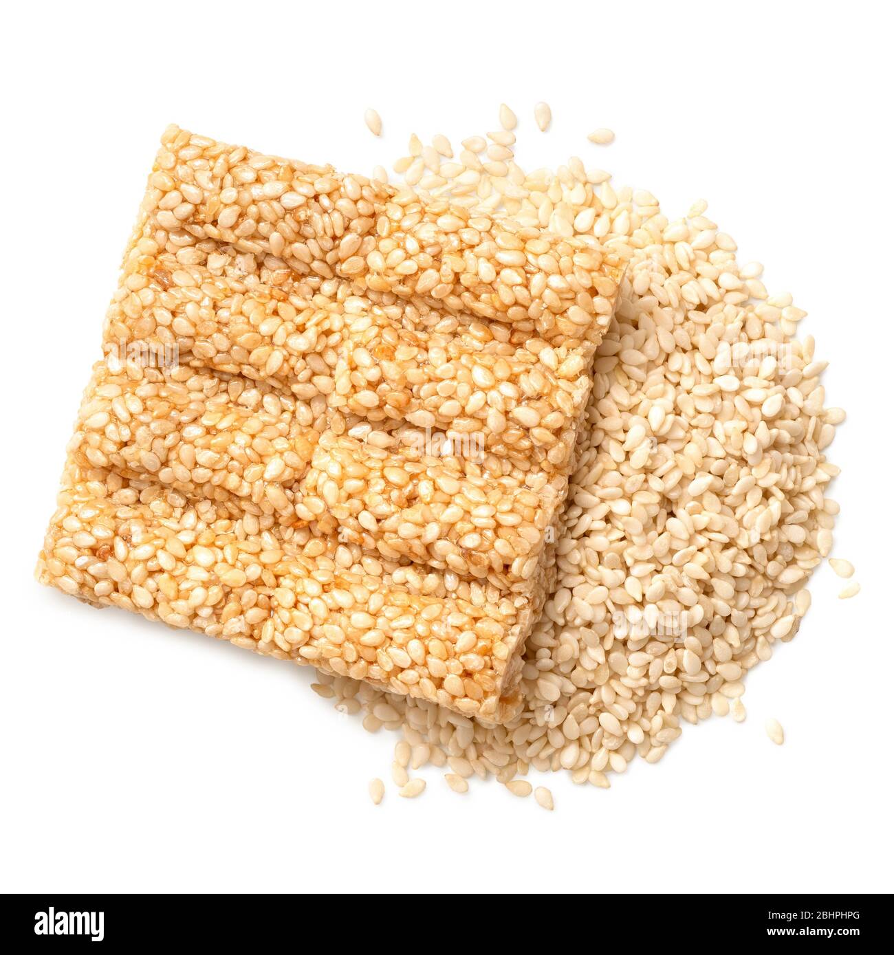 Square sesame seed honey bar on a pile of peeled sesame seeds isolated