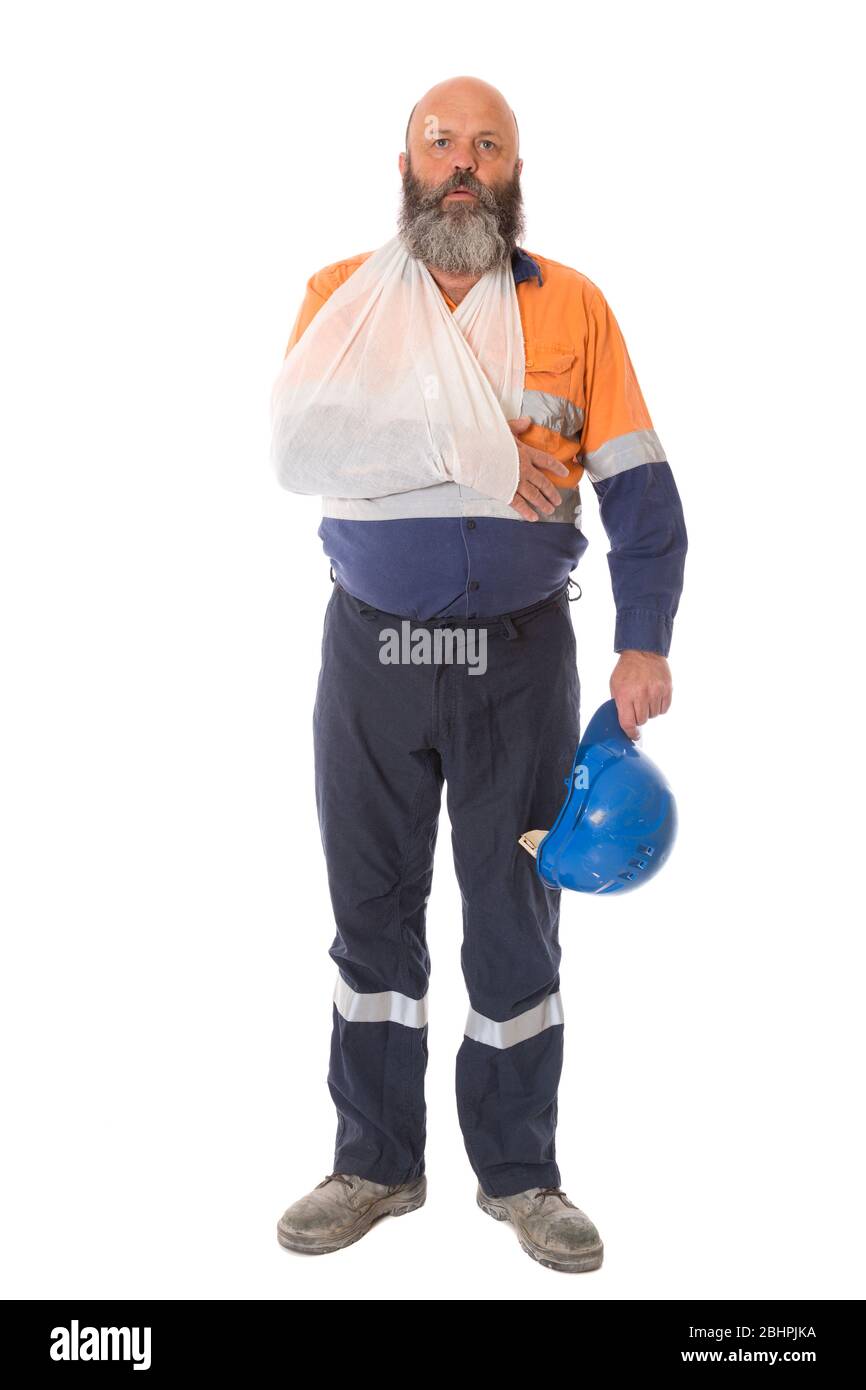 A full length image of an industrial worker injured in an accident with arm in sling, isolated on white. Stock Photo