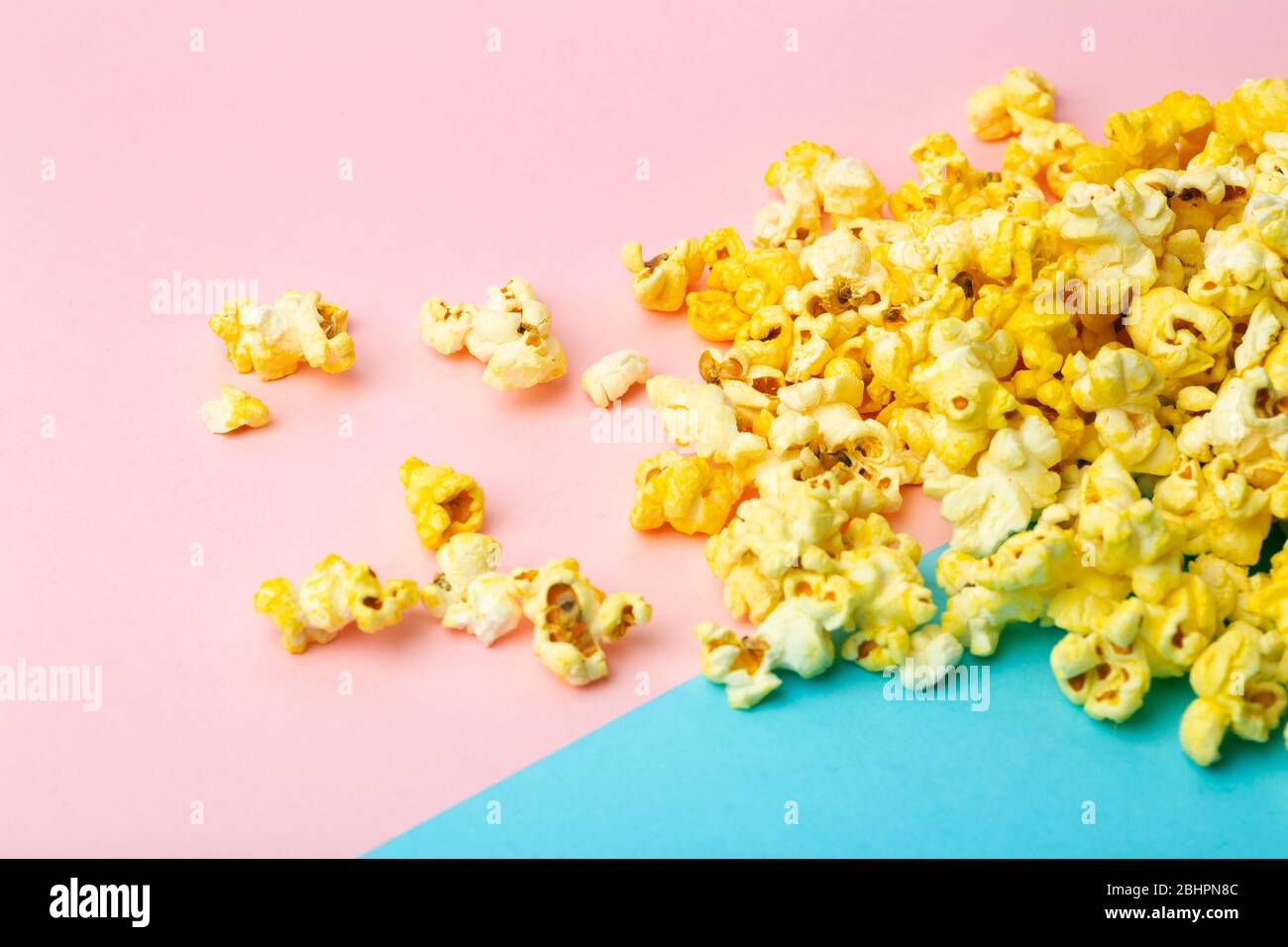 Popcorn on a colored background. Minimal food concept. Entertainment, film and video content. Aesthetics 80s and 90s concept Stock Photo