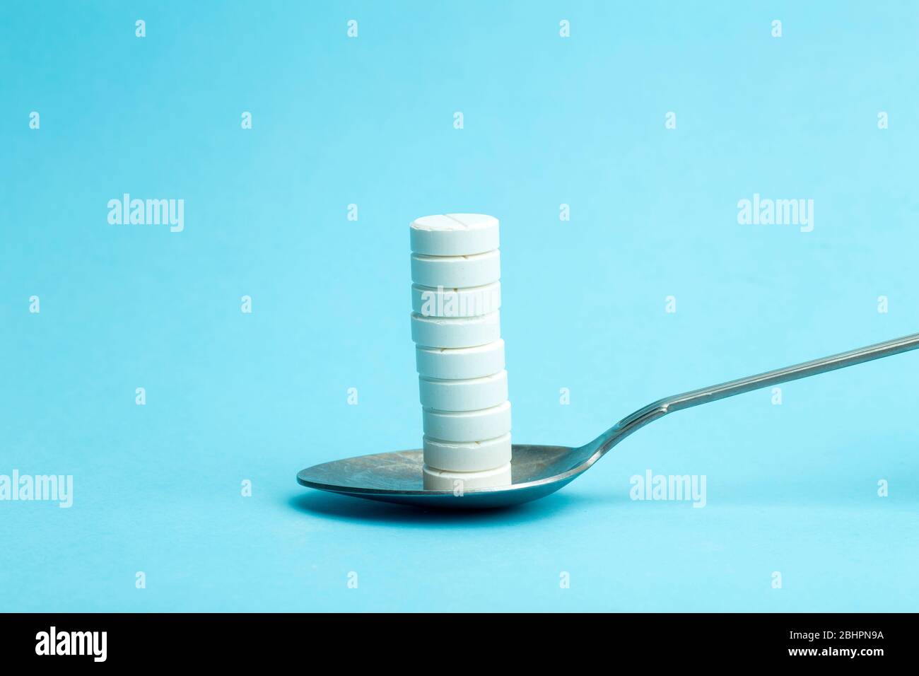 Pills and drugs on a spoon. Dosage and medication. Vitamins, anti-depressants, stimulants, sleeping pills and health concept. Pills and treatment addi Stock Photo