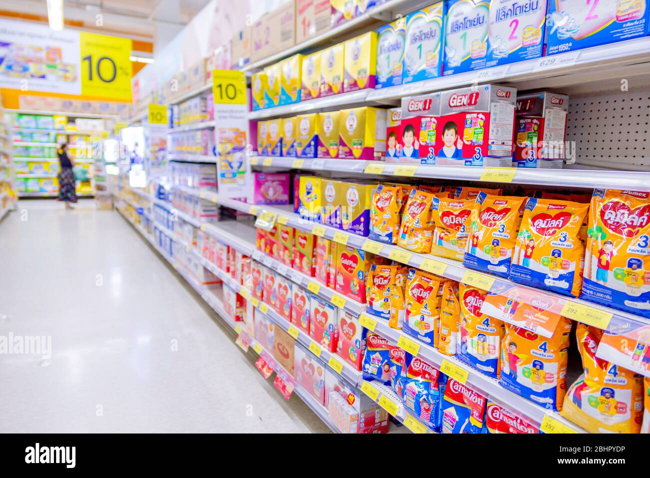 Many brands of baby powdered milk stacked on shelves in TYesco Lotus supermarket with Thai price in Baht. Bangkok, Thailand May 1, 2018 Stock Photo