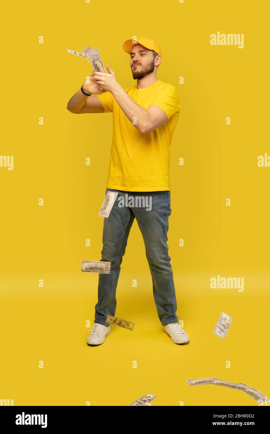 Cheerful excited ecstatic overjoyed man throwing money away showing his wealthiness isolated Stock Photo