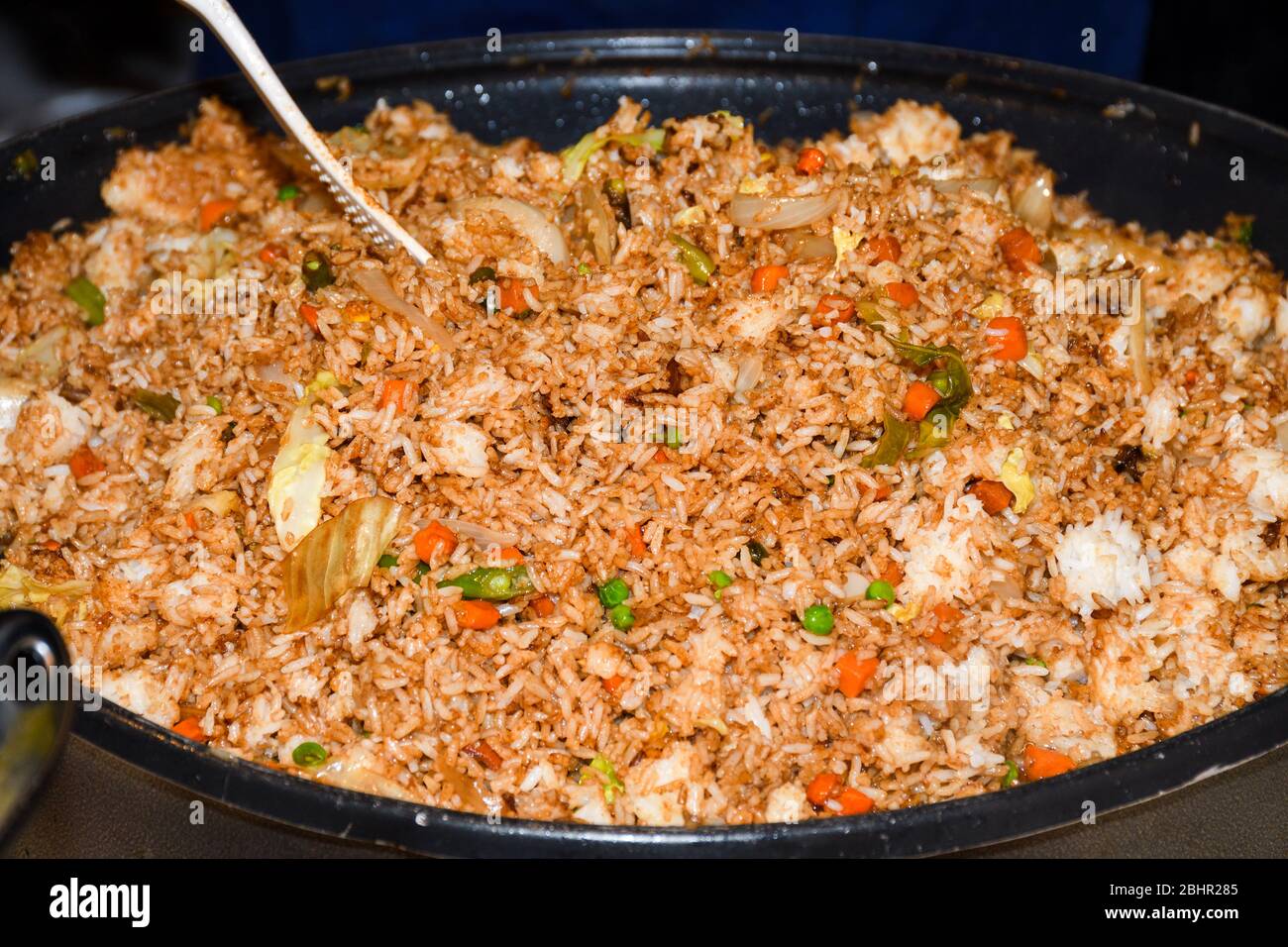 Asian fried rice with chicken. Prepared and served in a wok. Top view