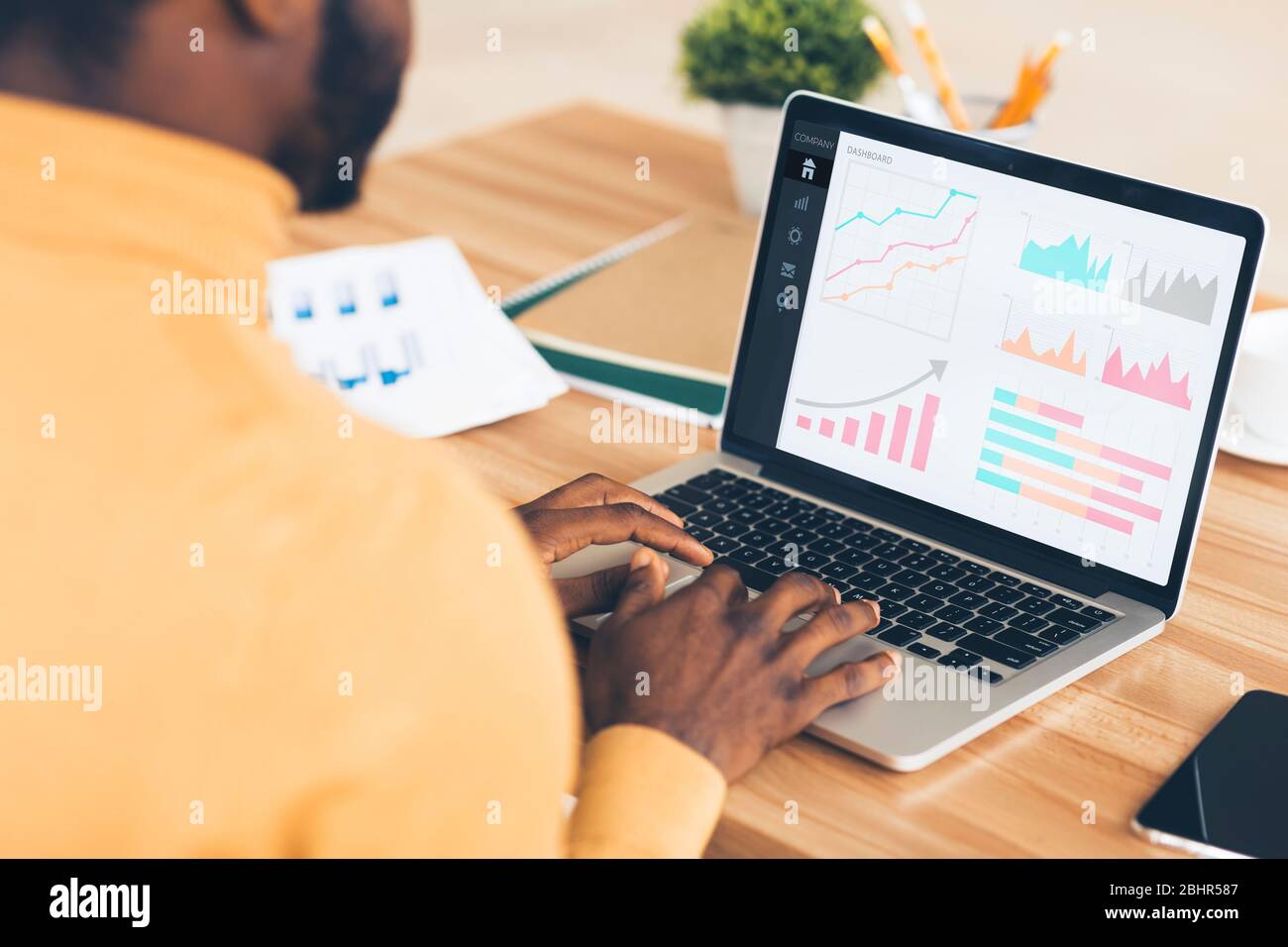 Black entrepreneur analyzing graph on laptop at workplace Stock Photo
