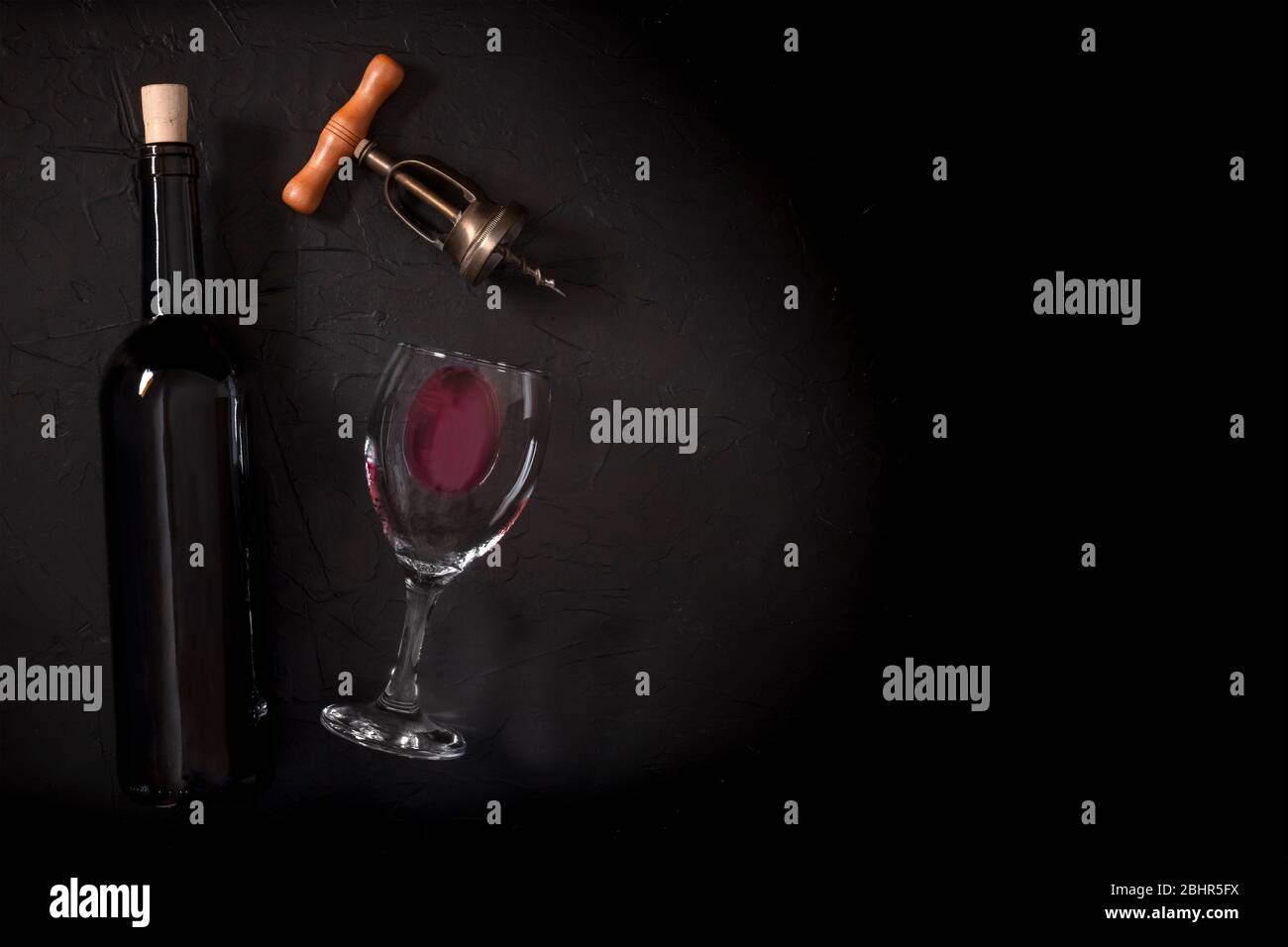 Wine tasting, top shot on a black background, with a cork, corkscrew, and a bottle, with a place for text Stock Photo