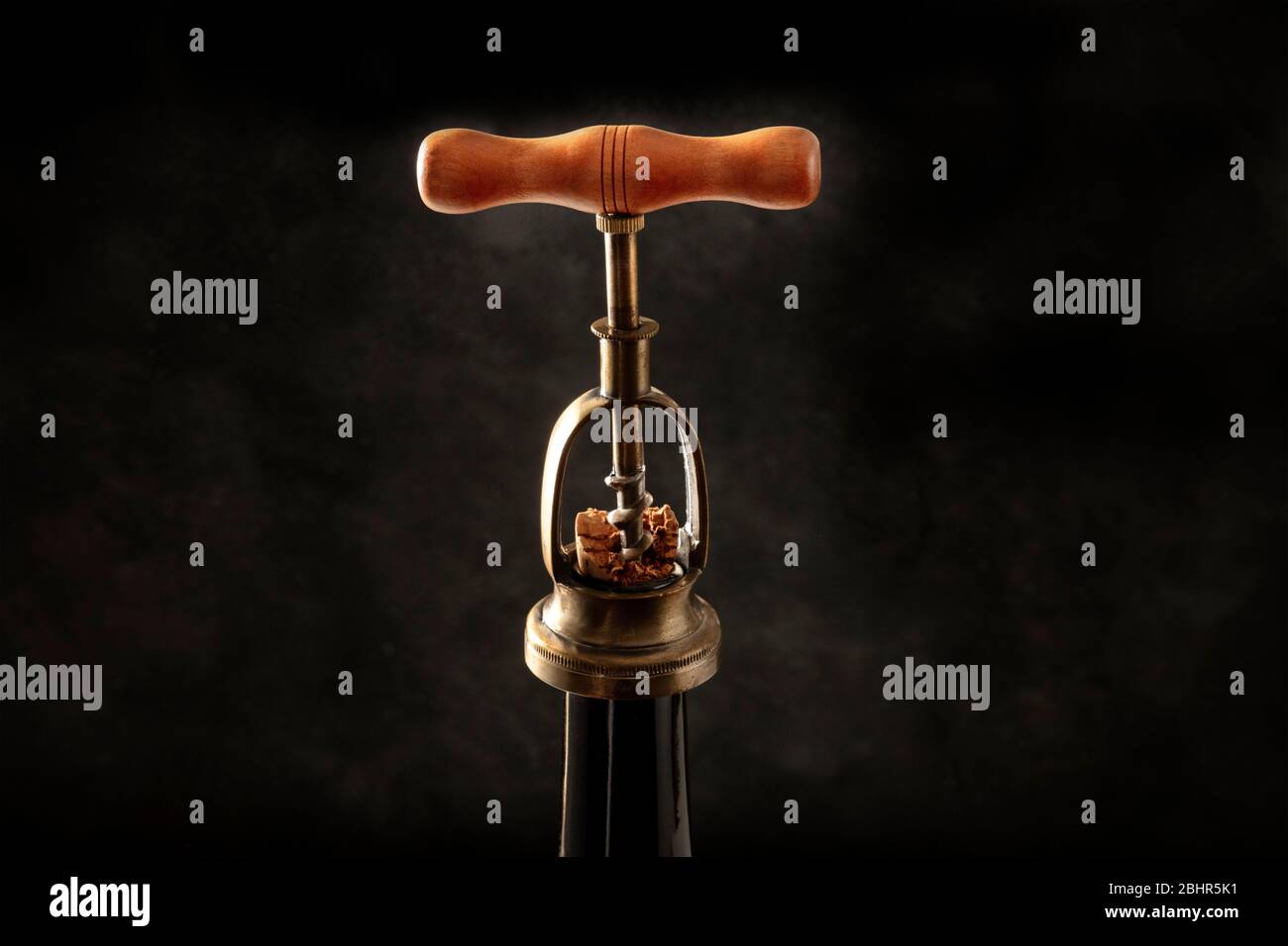 Wine design template. A vintage corkscrew, pulling out a cork from a bottle on a black background Stock Photo