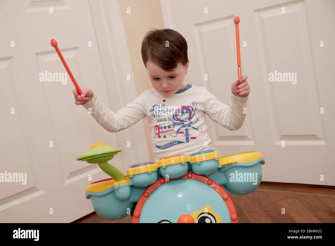 Two year old boy playing the drums at home Stock Photo