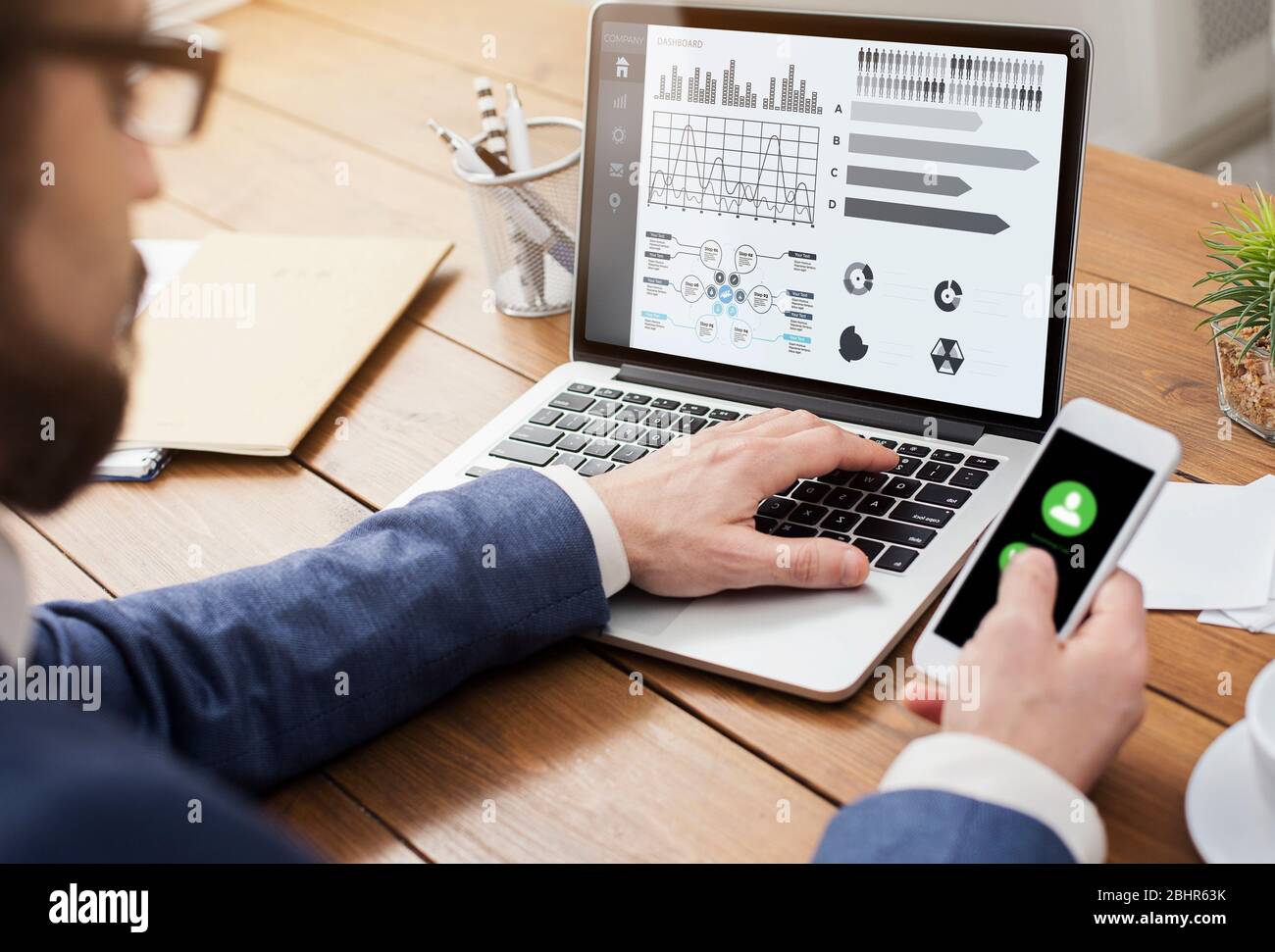 Entrepreneur analyzing graph on laptop at workplace Stock Photo