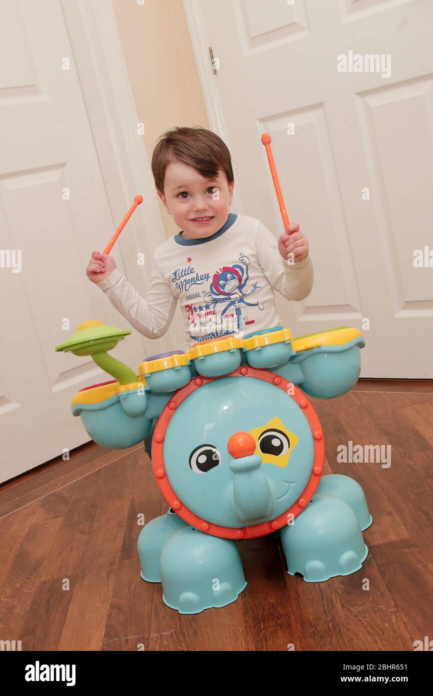 Two year old boy playing the drums at home Stock Photo