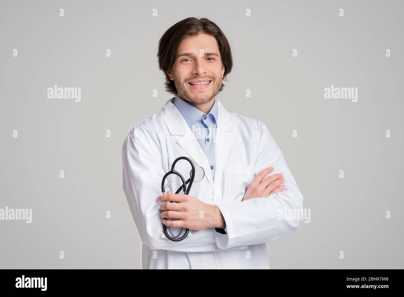 Reliable Medical Services. Confident Male Doctor Posing With Stethoscope In Hands Stock Photo