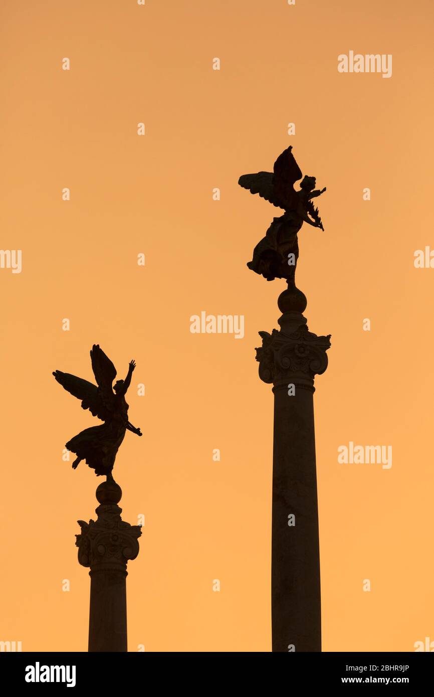 Rome, Italy. Angels on top of columns flanking the Monument to Vittorio ...