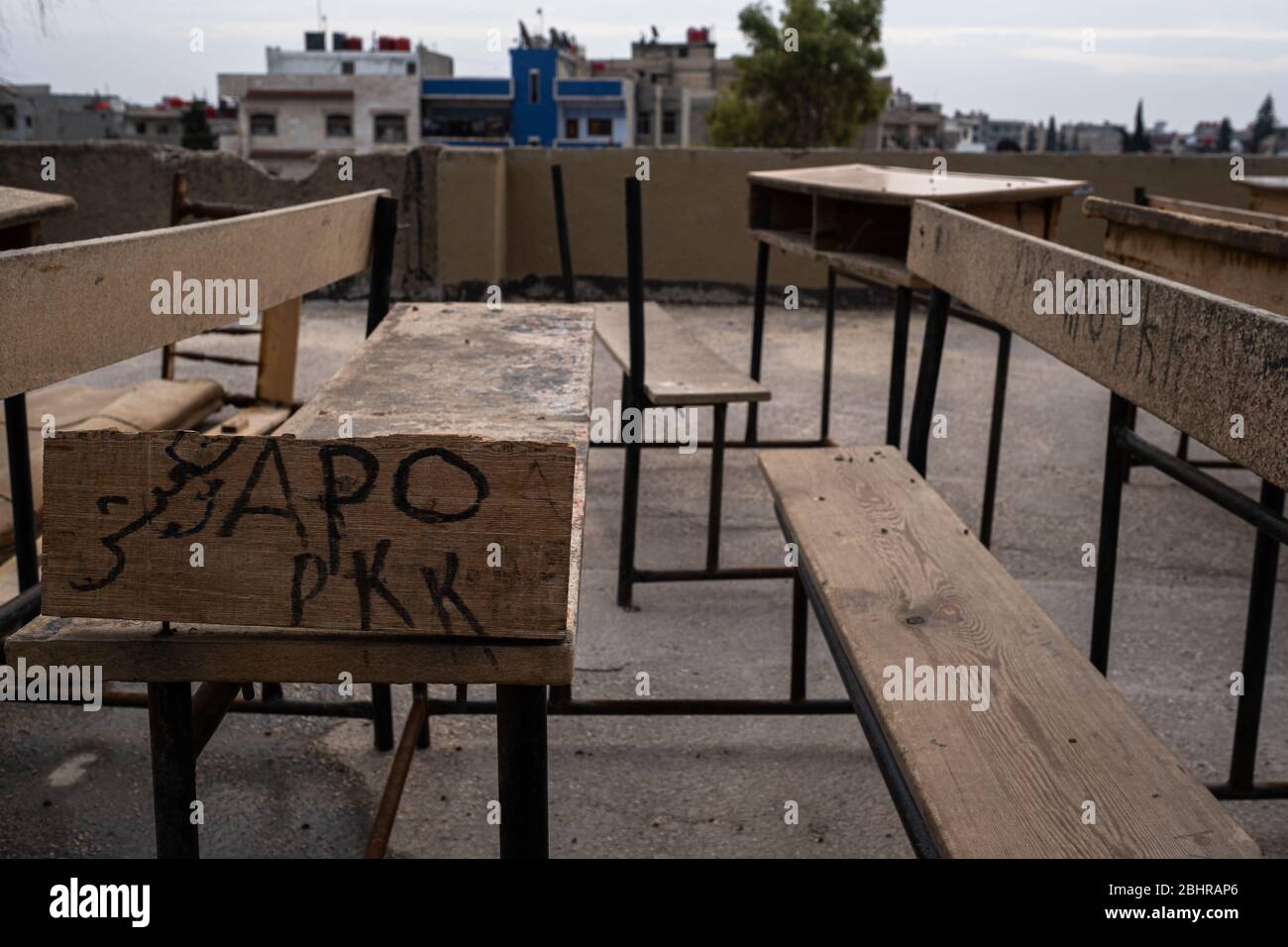 The relationship between education and politics is complex in Qamishli, North-East Syria. Old and broken tables are marked with graffiti for the PKK and Abdullah Ocalan, either terrorists or visionaries depending upon your perspective. Stock Photo