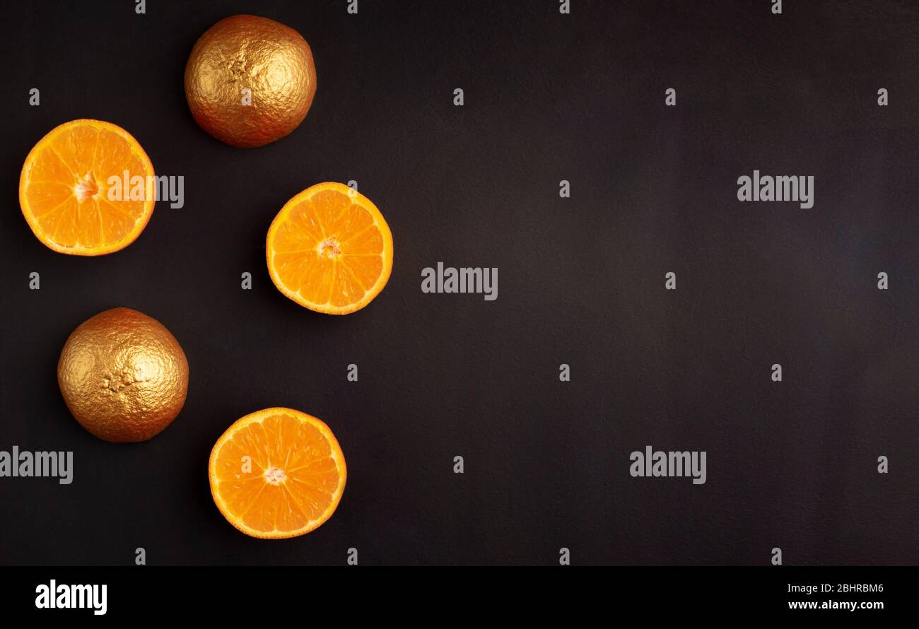 Halves of fresh oranges and painted with gold paint Stock Photo