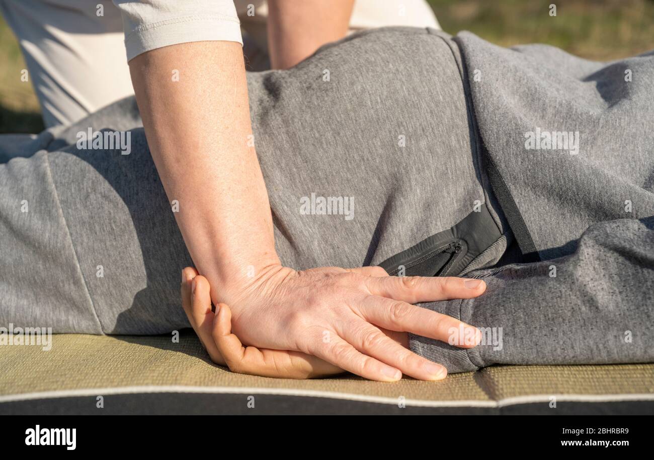 A Masseuse Pressing Down On The Hands Of A Client During A Shiatsu