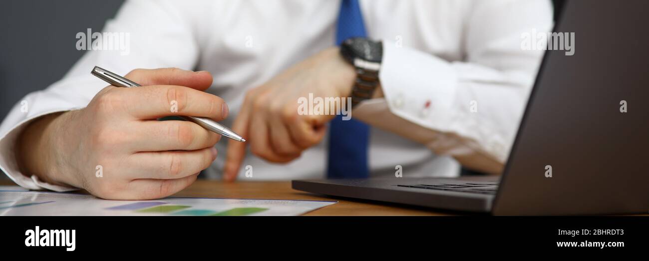 Office worker working on laptop and taking notes Stock Photo