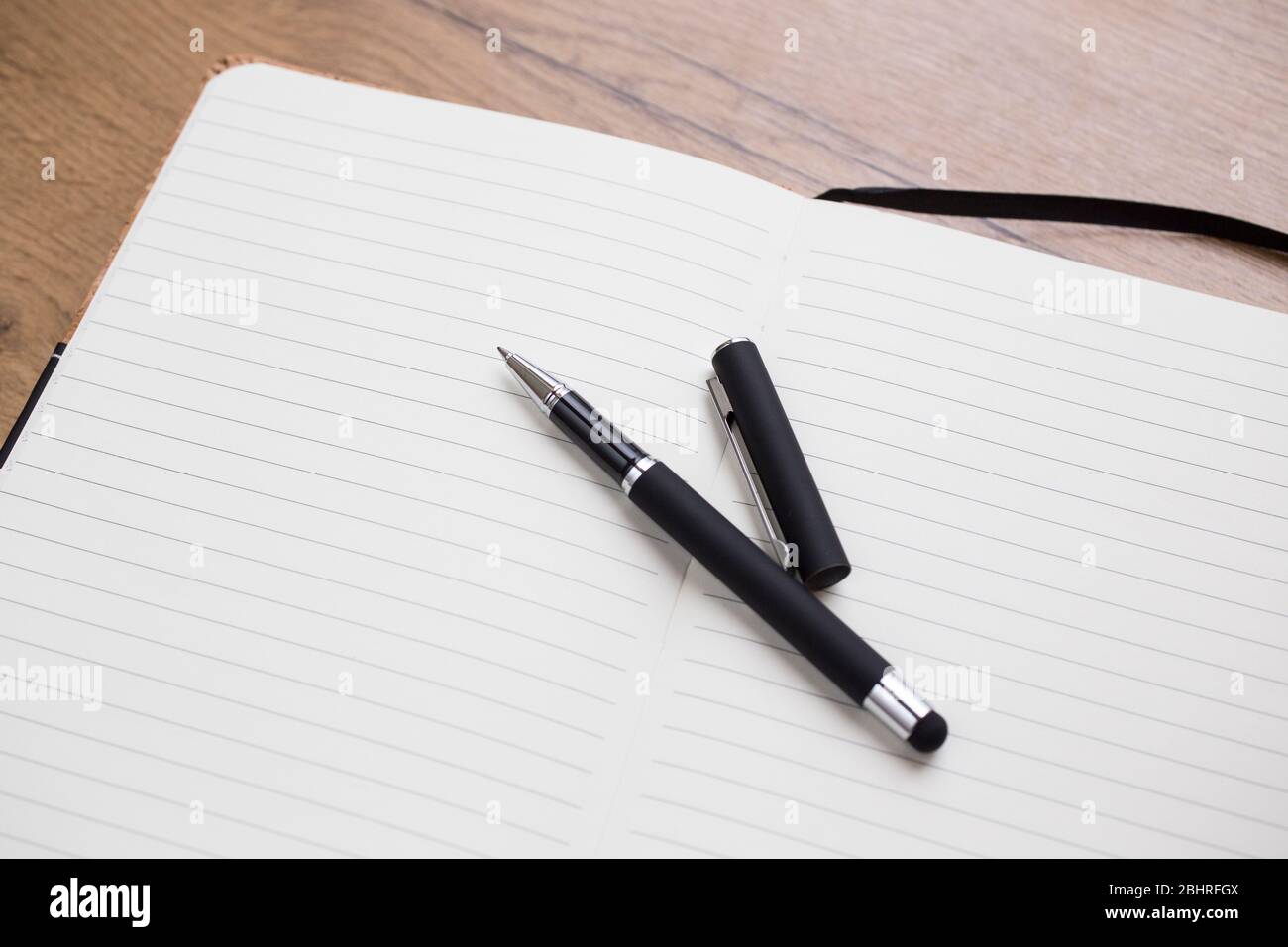 Empty Opened notepad with pen on wooden table Stock Photo