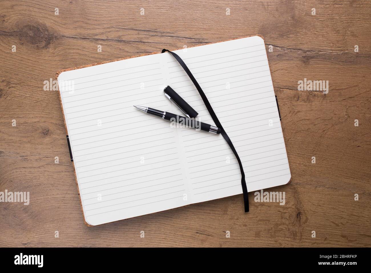 Empty Opened notepad with pen on wooden table Stock Photo