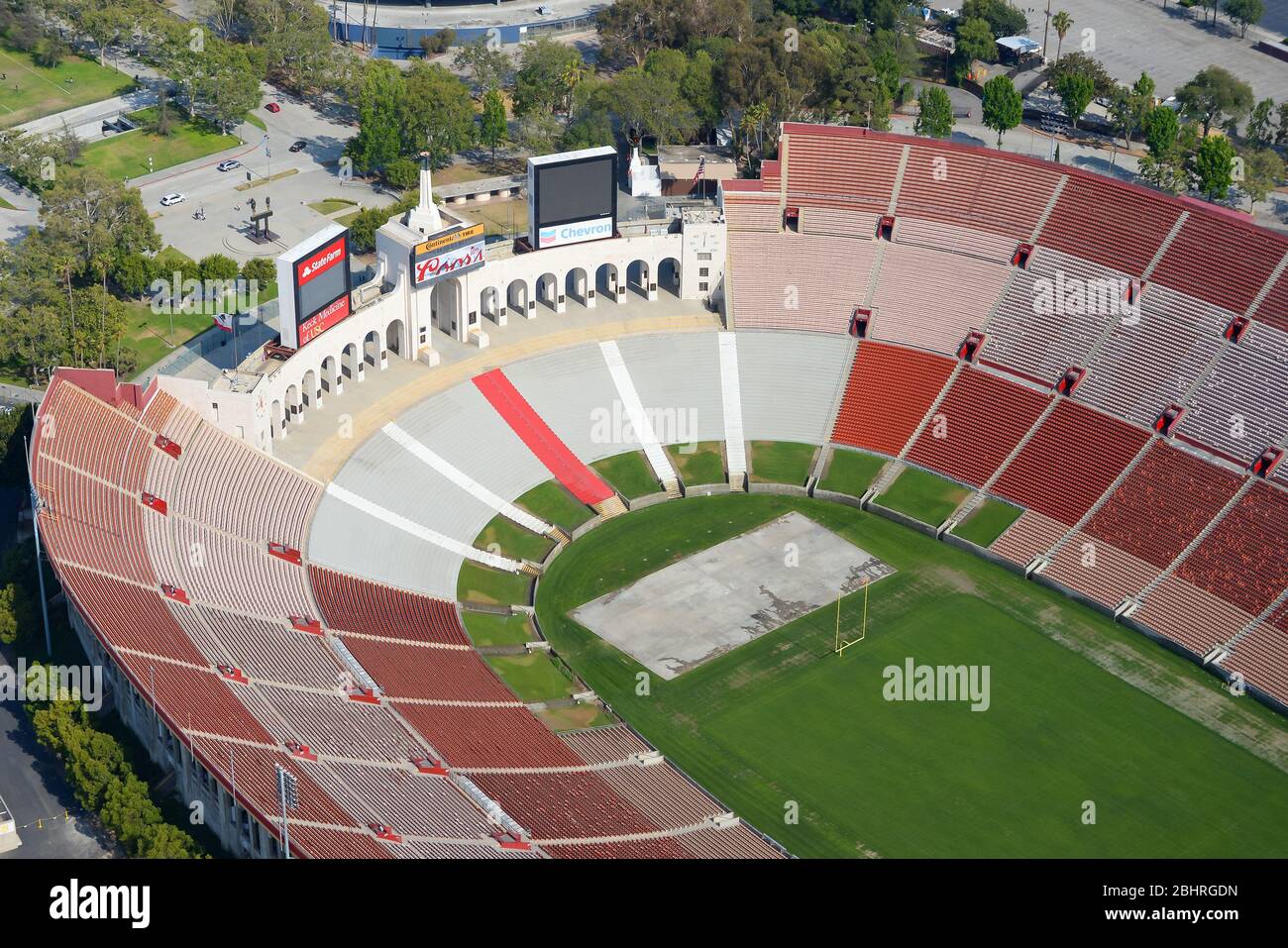 Close aerial view of Los Angeles Memorial Coliseum, a huge Olympic Stadium with a football field in California, United States. Empty sports stands. Stock Photo