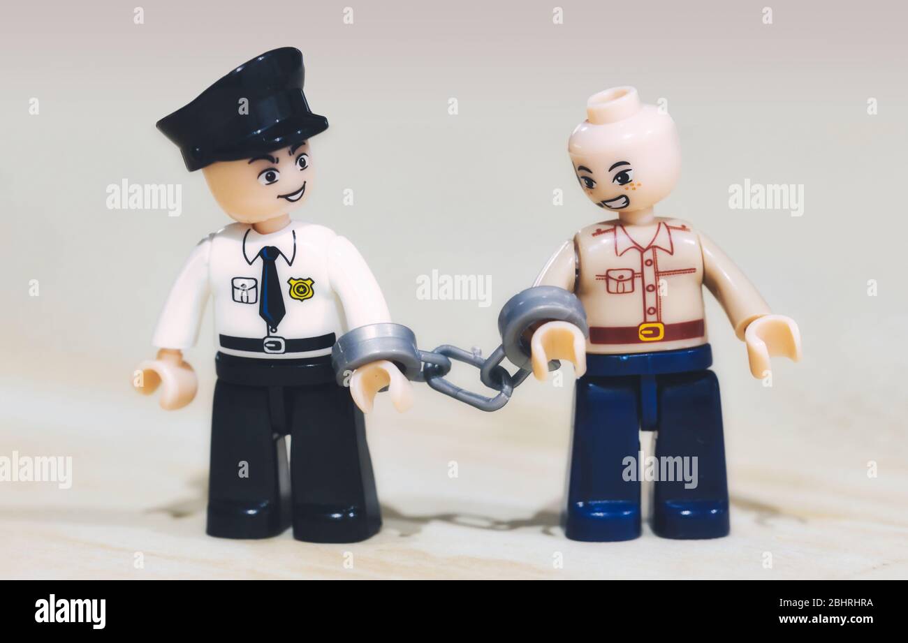 Toy miniature figures: a criminal being arrested by a policeman Stock Photo