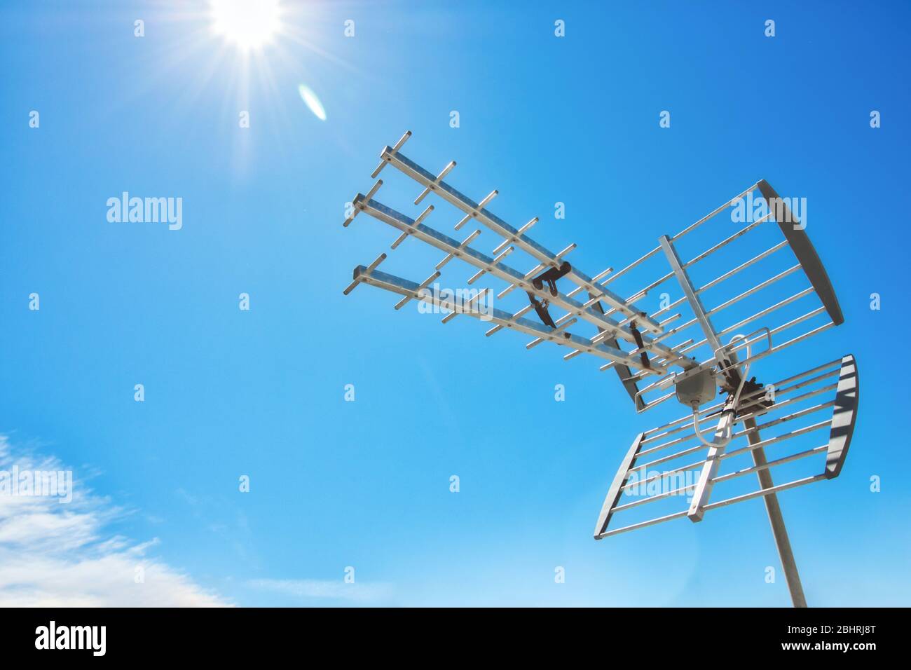 Television antenna on a rooftop against a clear sunny blue sky Stock Photo